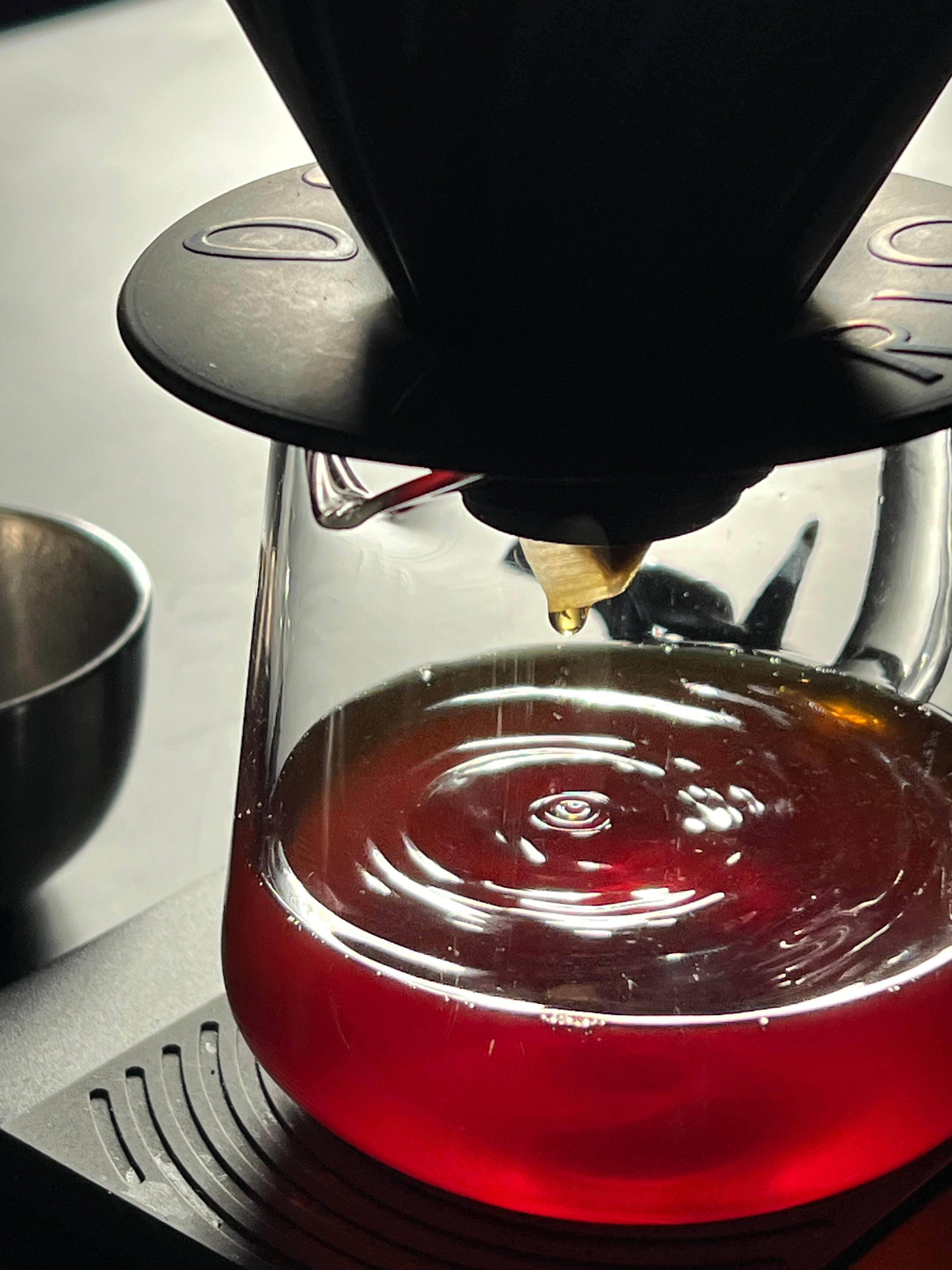 Coffee being poured from a portafilter into a glass carafe.